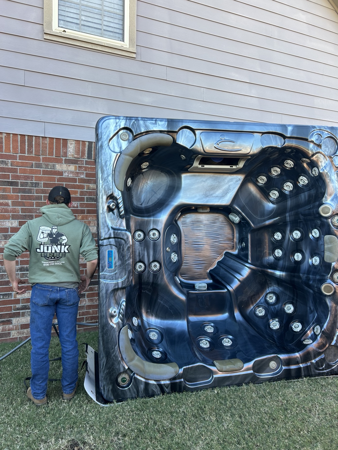 Junk Free crew beside a hot tub standing on its side