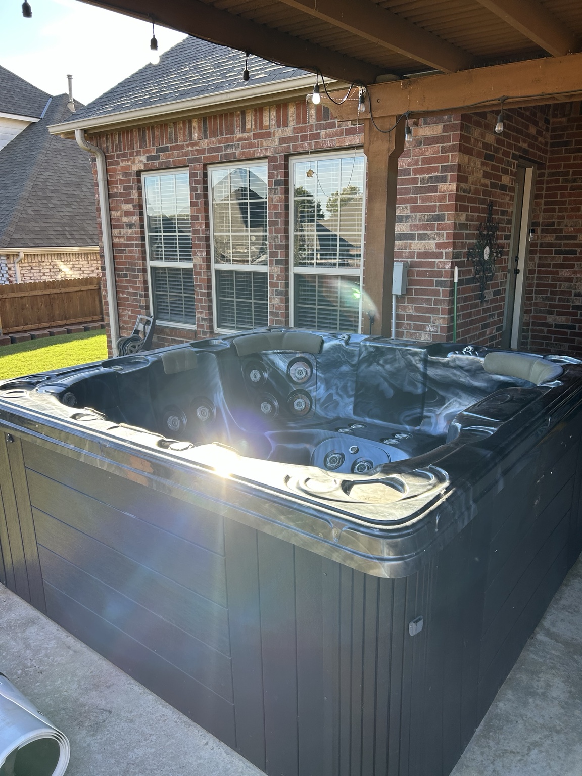 Hot tub on a covered backyard patio before removal