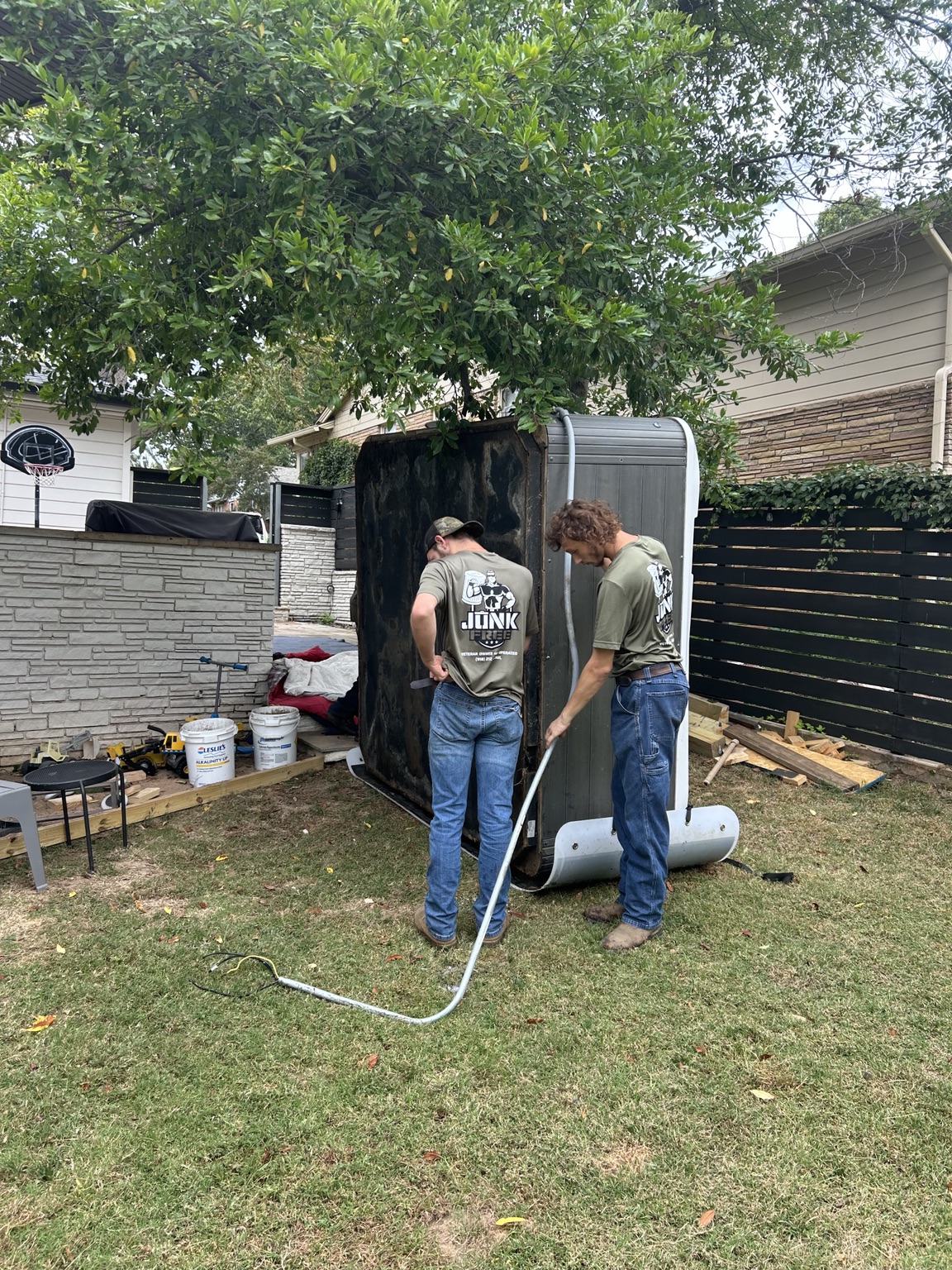 Junk Free crew moving a hot tub with lifting straps
