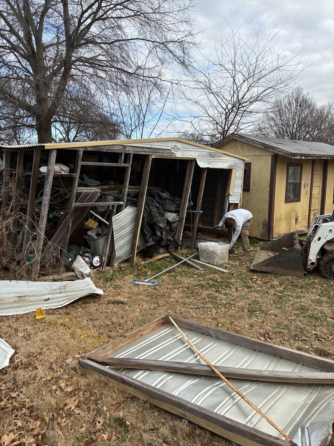Partly dismantled backyard shed with demolition debris