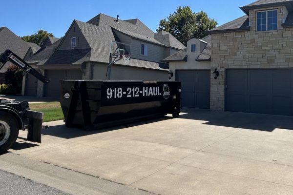 Black Junk Free roll-off dumpster in a residential driveway